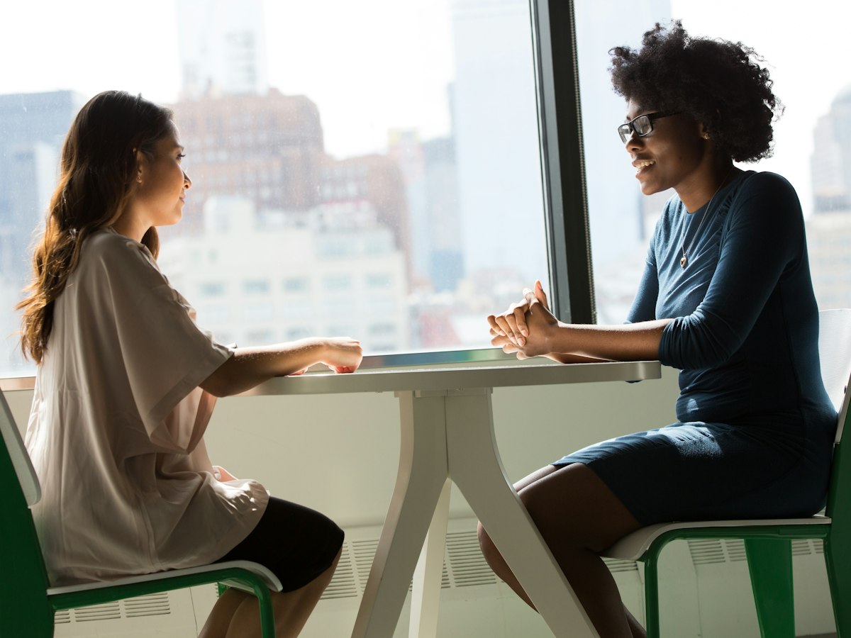 Two professionals discussing candidate requirements across a table