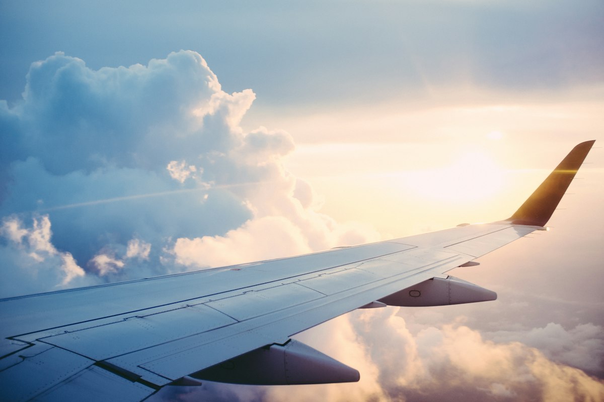 Aircraft wing above clouds during an international flight