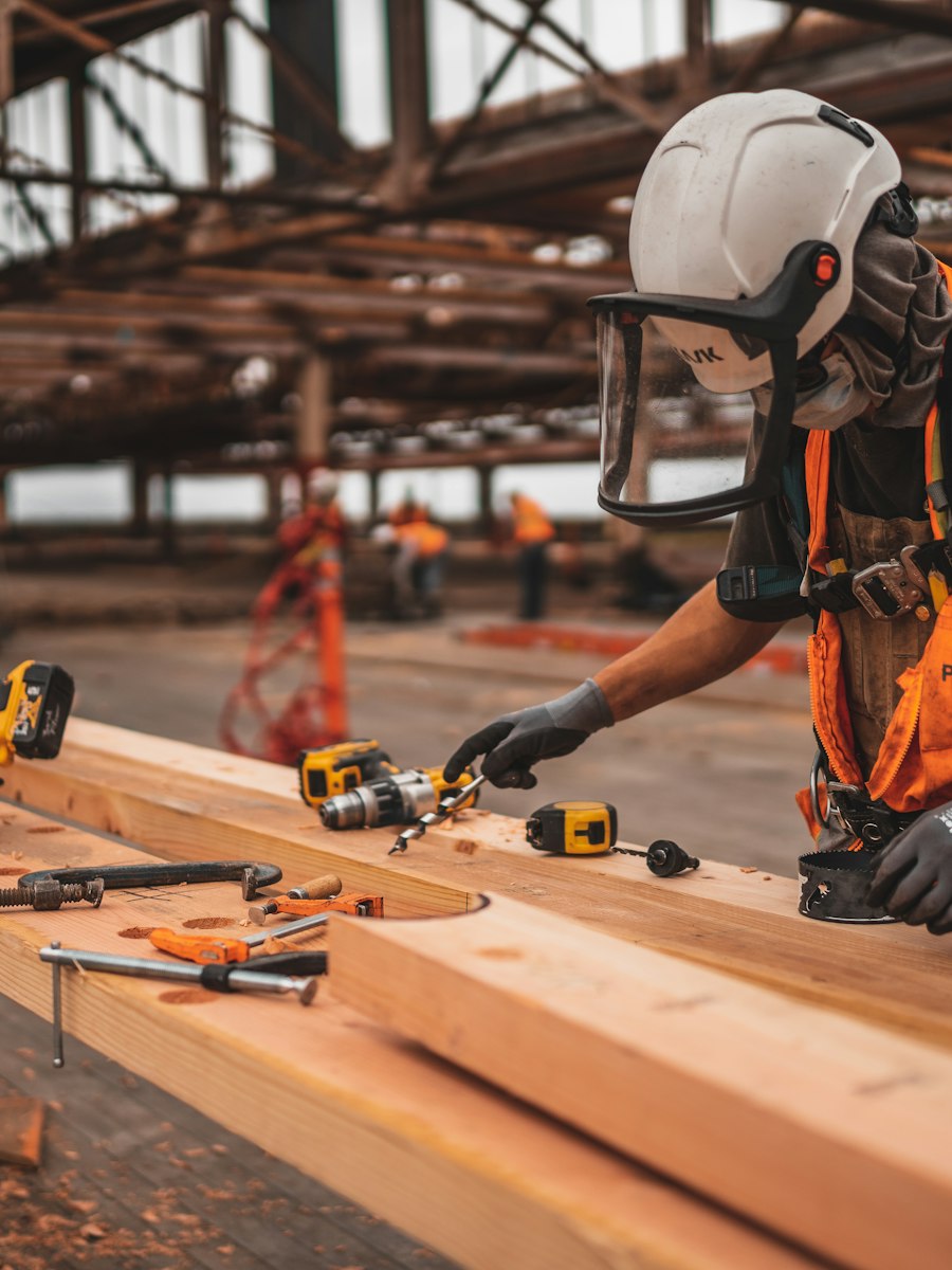 Carpenter using power tools while preparing timber on a construction project